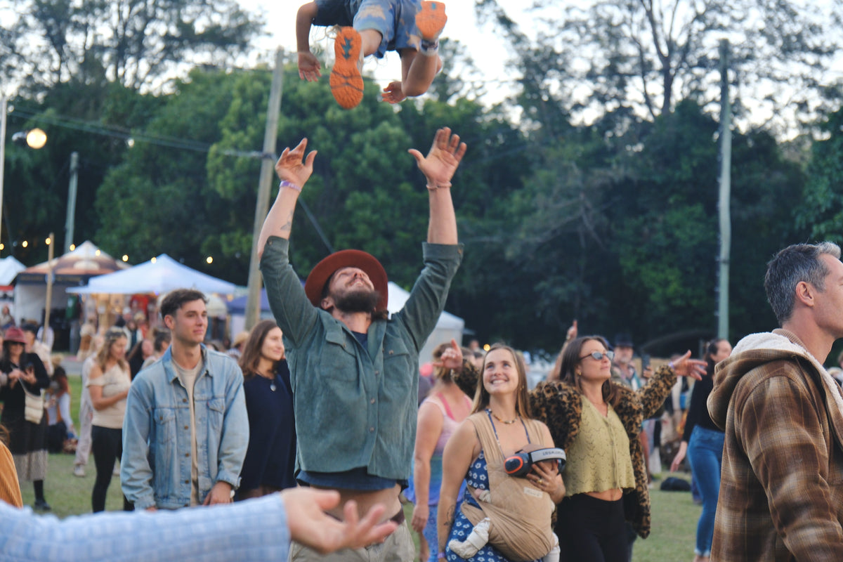 Brad tossing his child into the air at a community festival