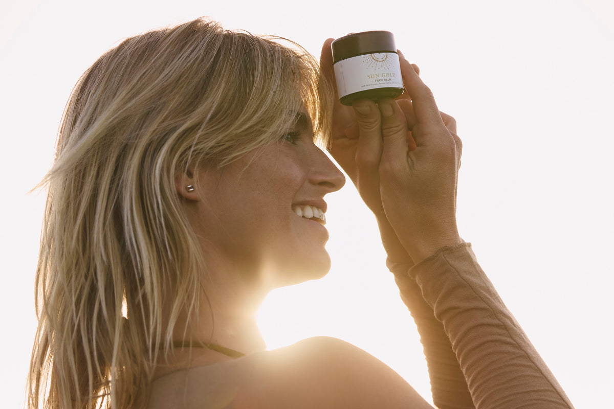 Sun Gold face balm held outdoors in natural coastal light