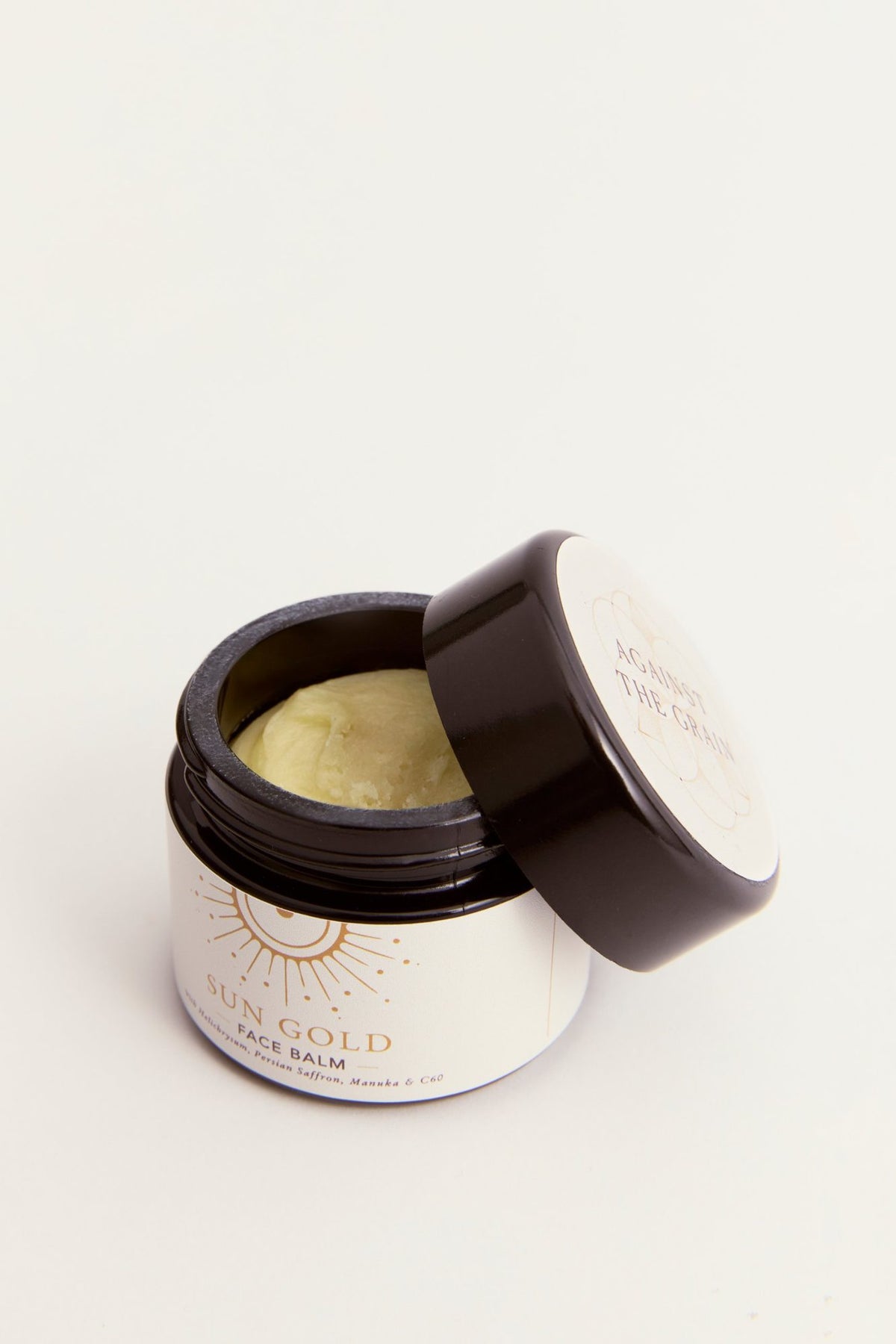 Open jar of Sun Gold Face Balm showing the golden balm texture